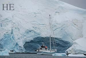 a sailboat gets up close and personal with an iceberg in antarctica