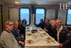 a group gathers for dinner about the vessel in antarctica