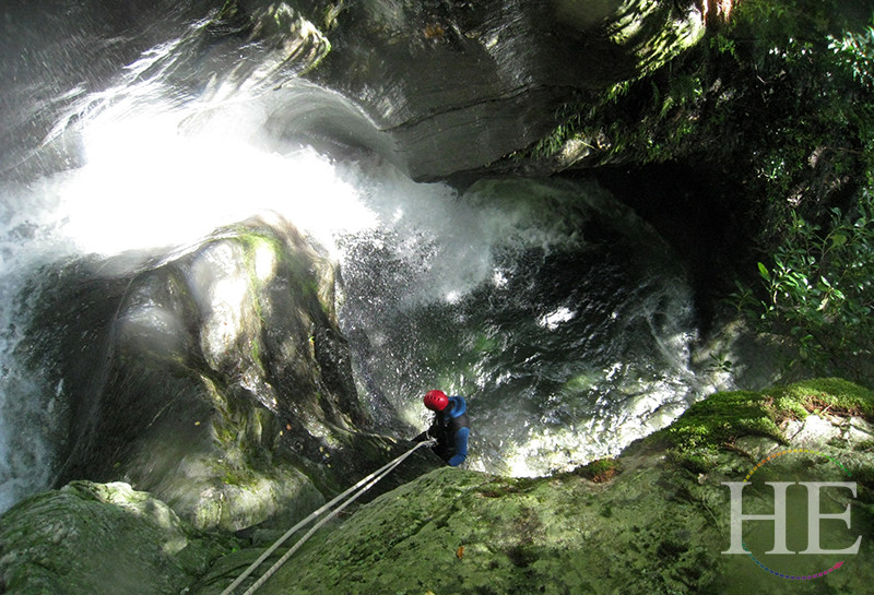 A person climbing down a cave on HE Travel's Wild Kiwi New Zealand Adventure Tour.