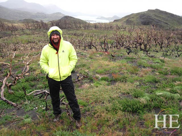 Zachary Moses wears a yellow rain jacket to hike in Chile with HE Travel