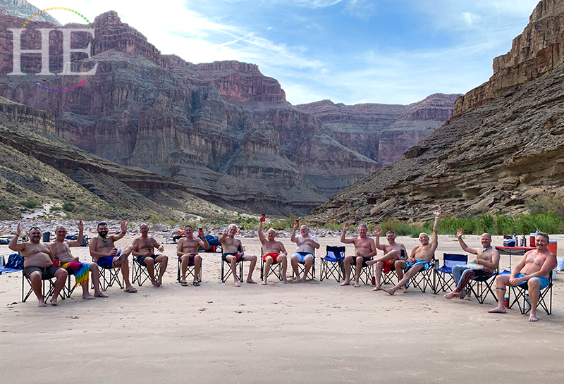 A group of travelers sits in chairs relaxing with the grand canyon in the background on HE Travel's Splash Grand Canyon Rafting Tour.