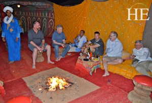 our group relaxes around the fire amongst beautiful tapestries on HE Travel gay Morocco cultural tour