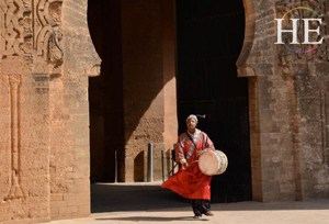 colorfully dressed drummer and ancient architecture on HE Travel gay Morocco cultural tour