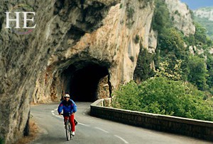 bicycling on a curving road through France on HE Travel gay biking tour
