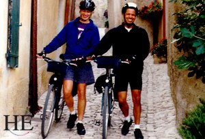 bicyclists walk their bikes down a narrow street on HE Travel gay biking tour in France