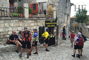 A photo of a gay travel tour taking a rest on the cobblestone streets of Le Baux on HE Travels gay French bike tour