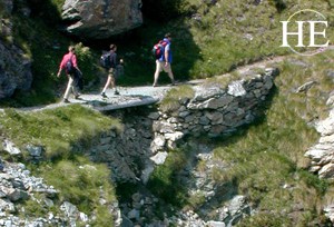Crossing a stone bridge while on HE Travel gay Swiss Alps hiking tour