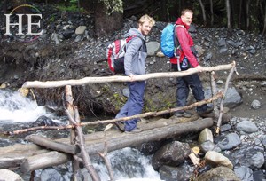 hikers cross a wooden bridge on the HE Travel gay adventure in patagonia Chile