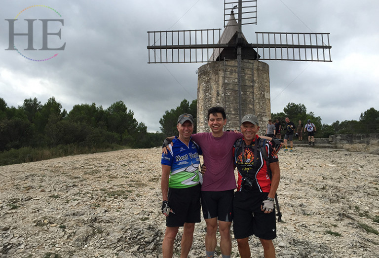 Posing in front of a windmill on HE Travel's Provencal gay France bike tour