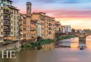 stunning sunset view of a boat beside the ponte vecchio bridge in florence