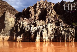 the colorado river is tinted orange on the HE Travel gay adventure Grand Canyon