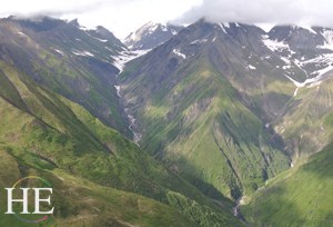 flying over green mountains on the HE Travel gay Alaska adventure tour