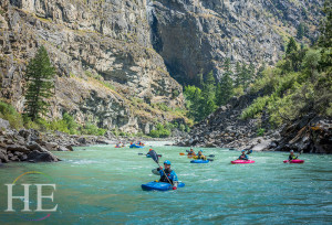 A group of adventurers on kayaks are going down the Salmon River on HE Travel's Middle Fork of the Salmon River Rafting Adventure.