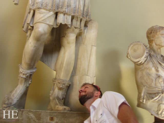 Zachary Moses peeks up a statues skirt in Rome on the HE Travel bike tour in Italy.