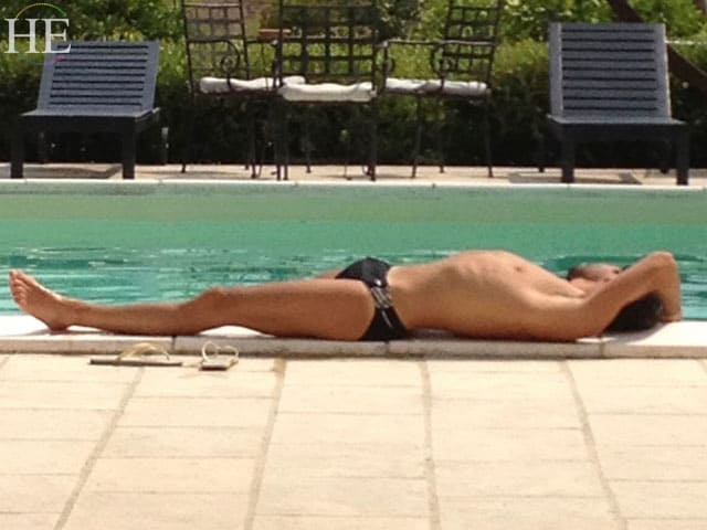 fit guy laying out by the pool on the HE Travel bike tour in Italy.