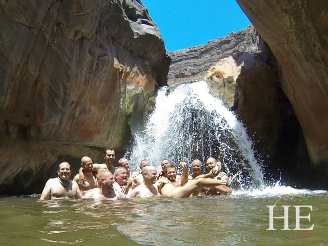 group of guys in a waterfall of the Grand Canyon with HE Travel gay group