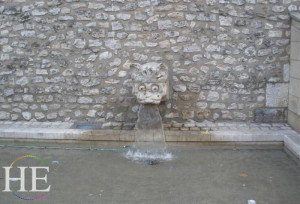 a gargoyle fountain spits water on the HE Travel gay bike tour in France