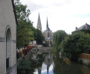 spires of a cathedral reflected in the river on the HE Travel gay France bike tour