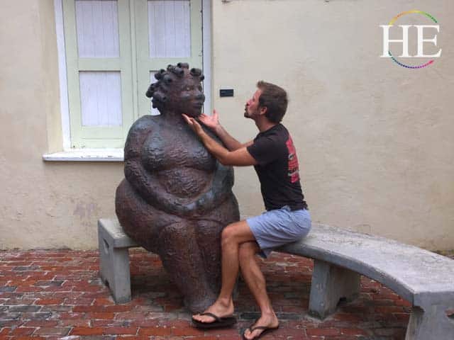 Zachary Moses helps a statue find inner worth at museum kura hulanda willamsted curacao gay travel tour