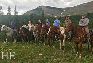 a happy group on horseback pose in glacier national park montana
