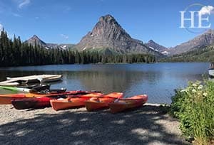 kayaks wait patiently for adventure on a lake in glacier national park montana