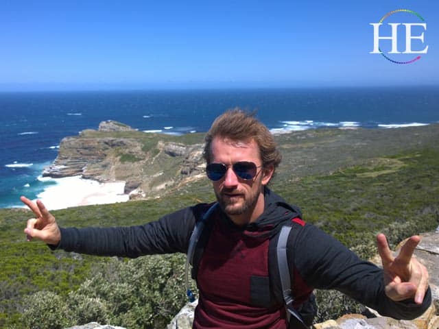 Zachary Moses posing on a cliff overlooking cape point in south Africa