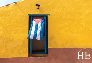 cuban flag in a window of a yellow building on the gay Cuba trip with HE Travel
