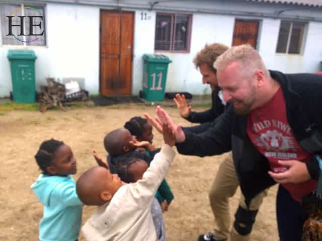 zachary moses and john michael lowry give high fives to kids in south african township