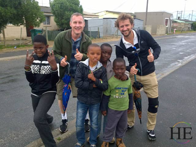 zachary moses and lou smith pose with kids in south african township