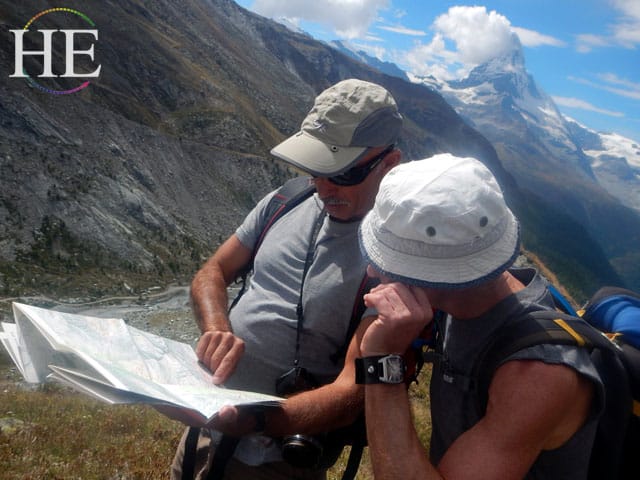 consulting a map of the swiss alps on the HE Travel gay hiking tour