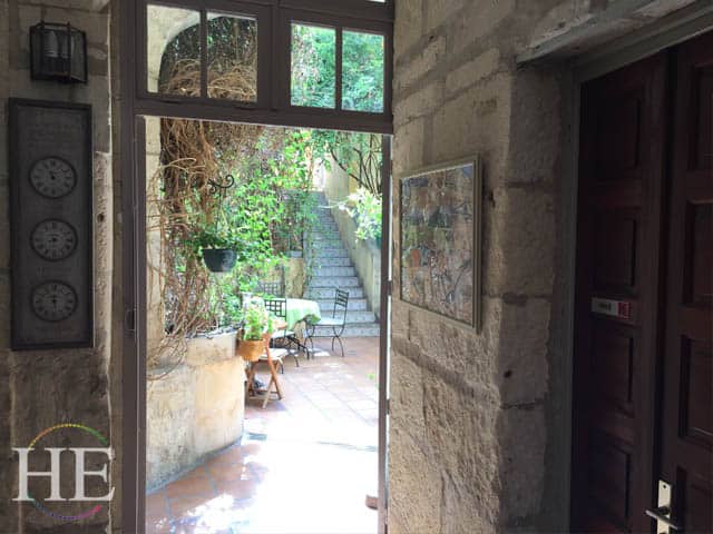 a view through a dorrway into a courtyard of a hotel in arles france
