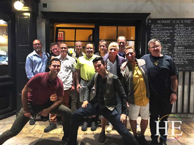 A group of men on the he travel provencal tour of france posing in front of a restaurant