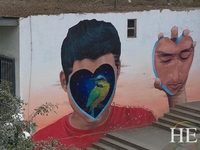 painting of a man on wall in lima peru. his face is torn off replaced by space bird