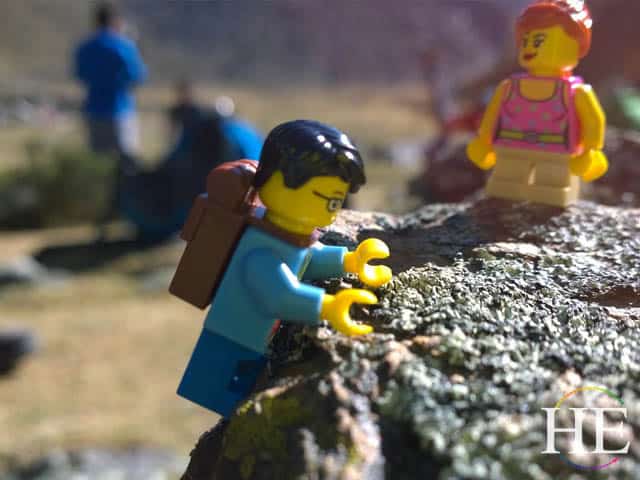 poor little lego man struggles to climb over the rock