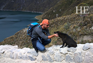 Zachary Moses stops to give a cat some scratches on HE Travel's gay Ecuador Cotopaxi Adventure