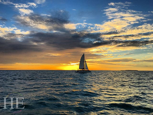 Sailboat on the ocean infront of a warm Key West sunset.