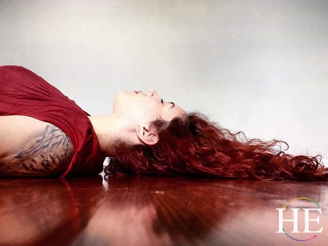 julianne's curly red hair drapped on a stained red floor