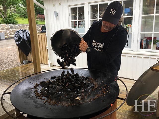 fresh mussels are poured onto an outdoor grill at musselbaren in west sweden