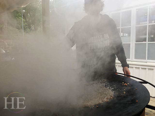 a cloud of steam after white wine is added to an outdoor mussel grill at musselbaren in west sweden