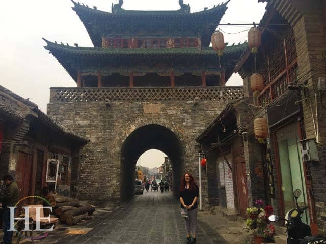 julianne keskey stands in front of an ancient gate in luoyang china