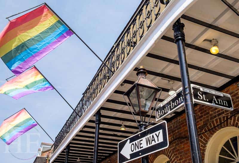 Colorful Gay Pride Flags flowing in the air at the corner of Bourbon Street and St. Ann on the HE Travel New Orleans holiday