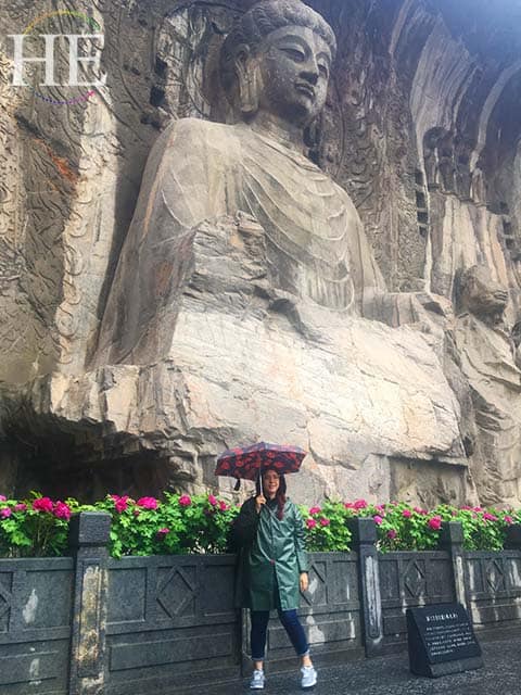 julianne stands in front of the largest buddha statue at longmen grottoes in luoyang china