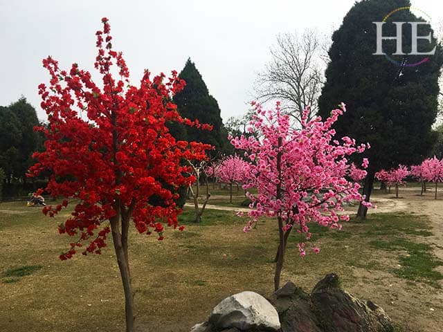 fabric flowers adorn a group of trees at a park in zhengzhou
