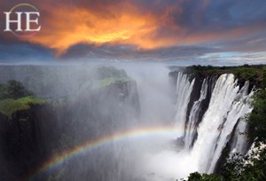 magnificent view overlooking Victoria Falls with rainbow and orange sky on the HE Travel Gay Safari
