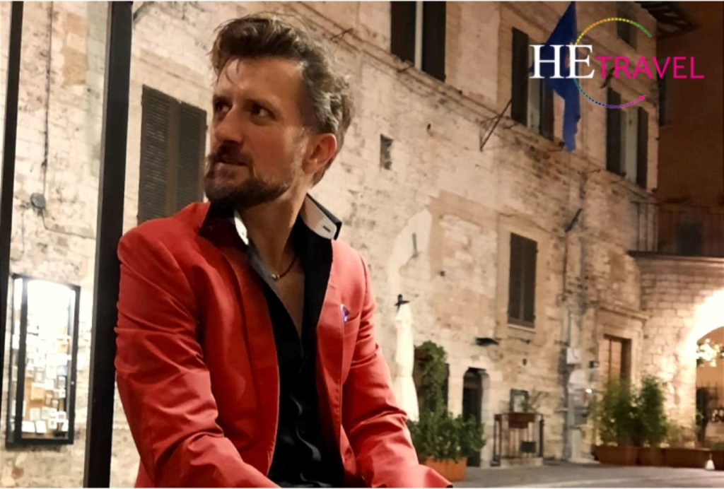 zach moses sits in umbria town in red jacket