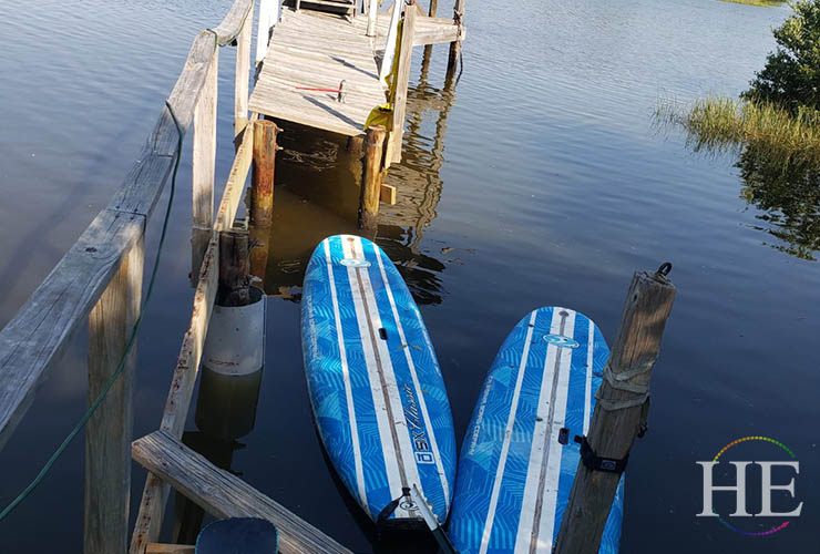 two paddleboards sit within broken section of dock