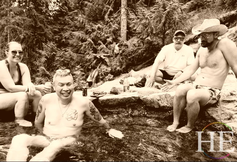hetravel tour group in hot tub with forest background, three men one woman