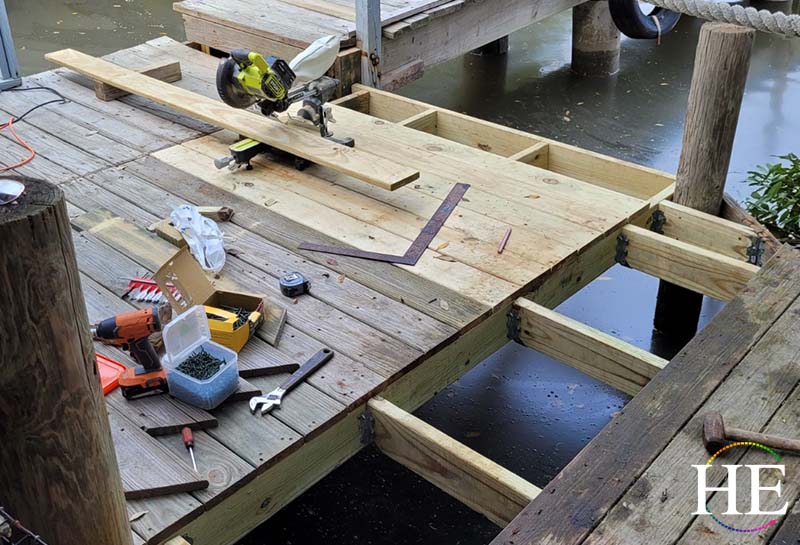 Dock being repaired. Tools in sight are a chop saw a square and several wrenches