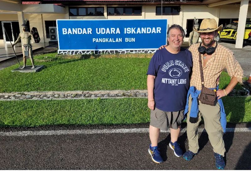 Zach Moses and Ed in Indonesia, they're posing with each other by the airport sign
