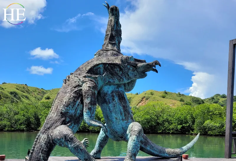 Statue of two komodo dragons fighting, One has their arm in the other's mouth.